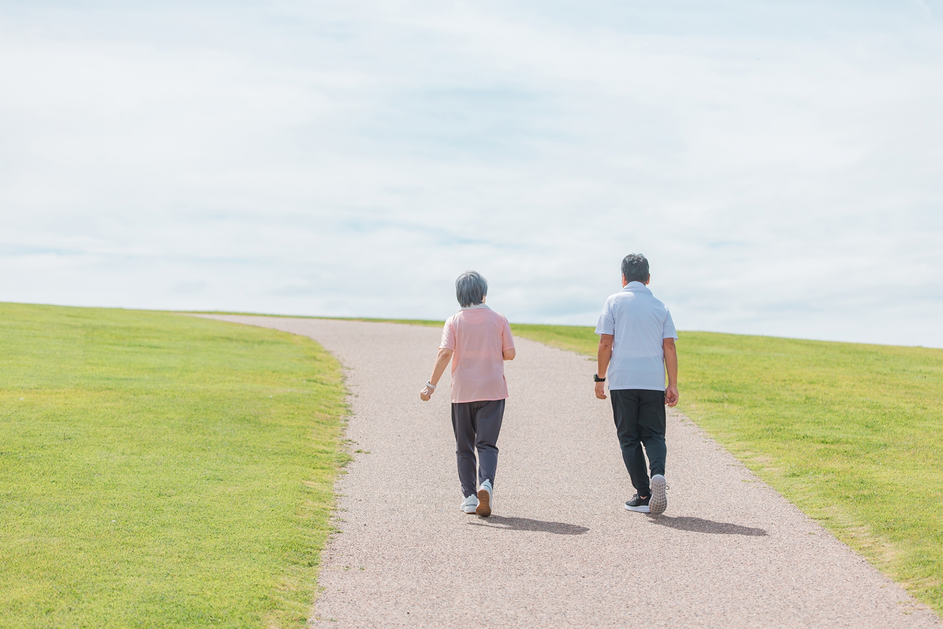 陽の光を浴びて散歩する高齢のご夫婦